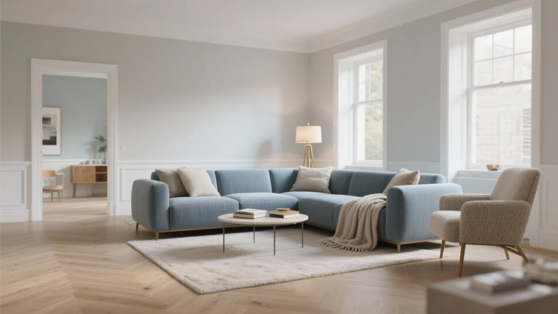 Spacious living room featuring blue corner sofa white rug round coffee table and large bright windows