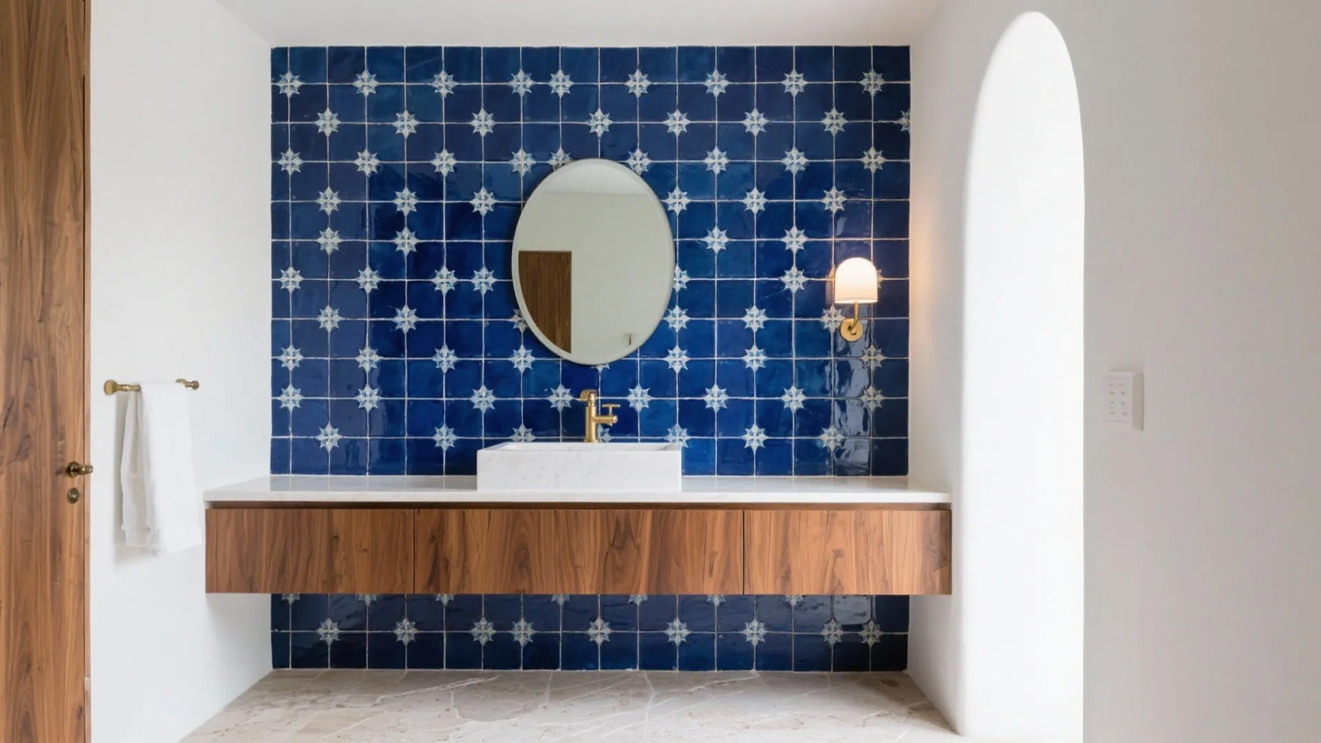 Bathroom interior with blue pattern wall tiles round mirror white sink and floating wooden storage cabinet
