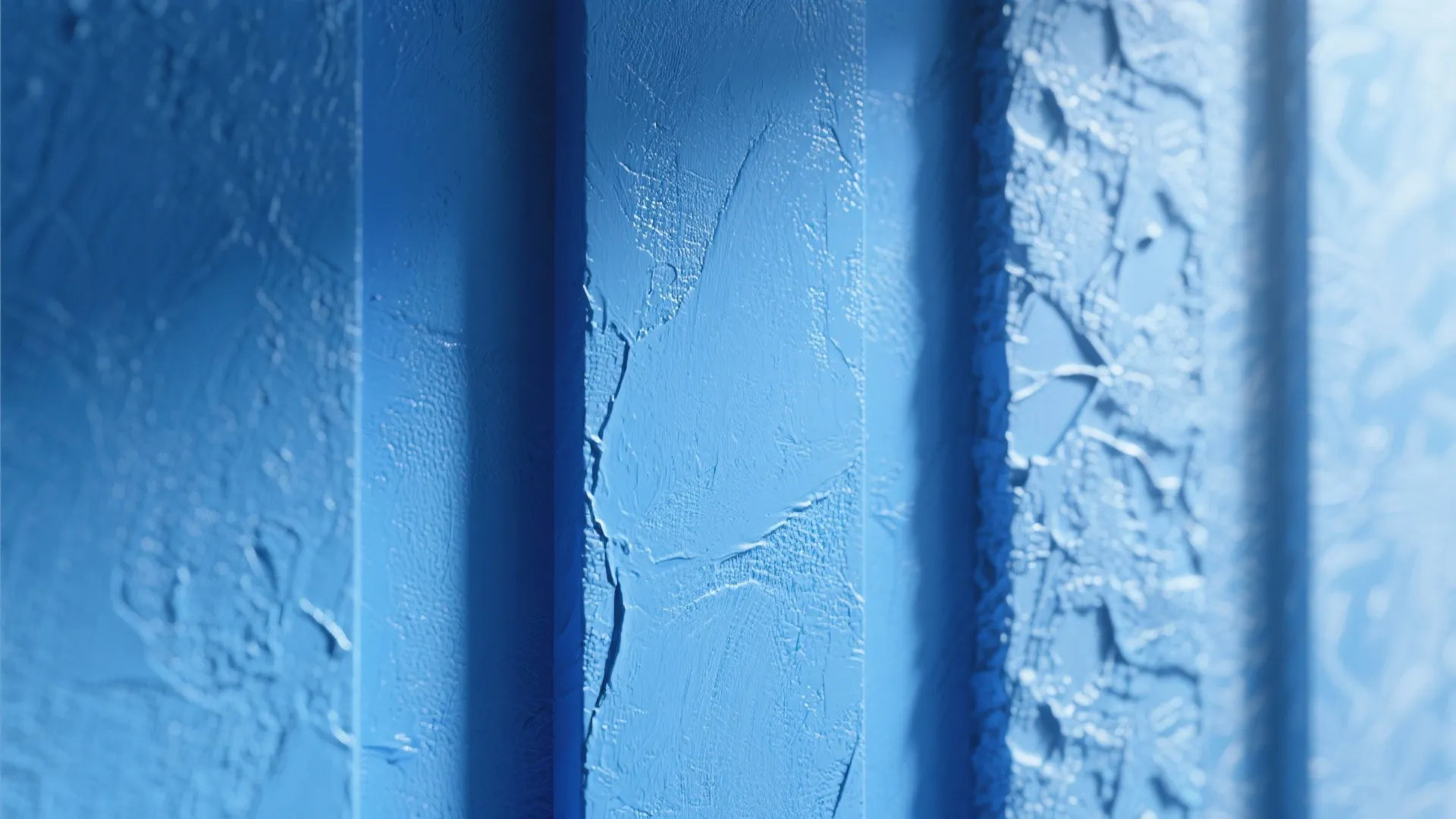 Macro view of matte, satin, and textured blue wall finishes showing surface detail and light reflection.
