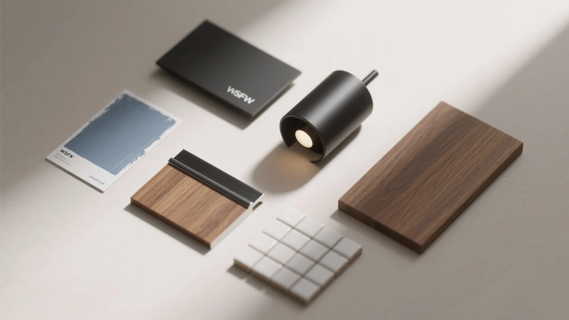 Flatlay of blue-gray paint swatches, matte black fixture samples and warm wood finish for a bathroom palette.