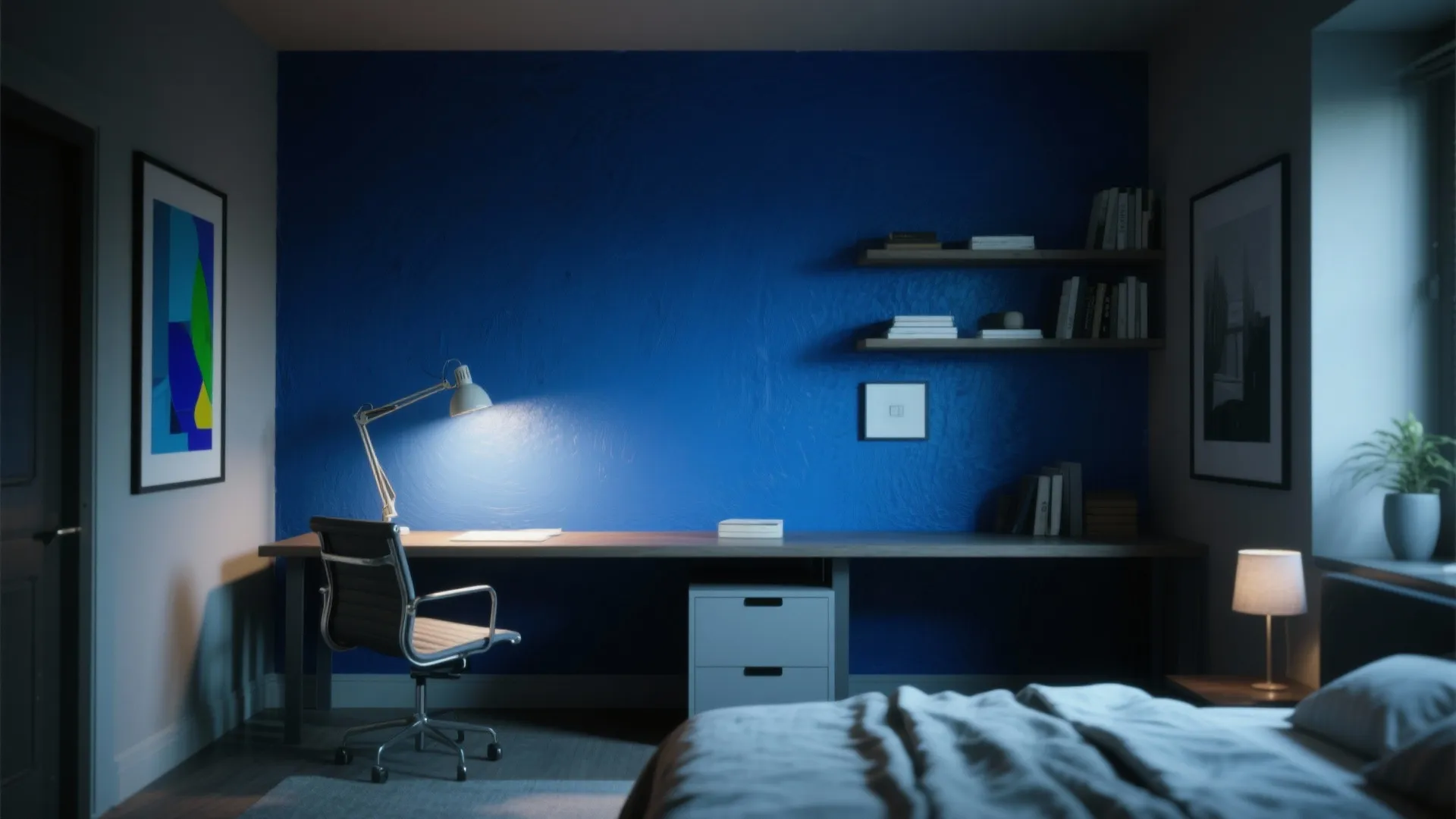 Home office with deep blue wall, long wooden desk, black chair, shelves, and a bed