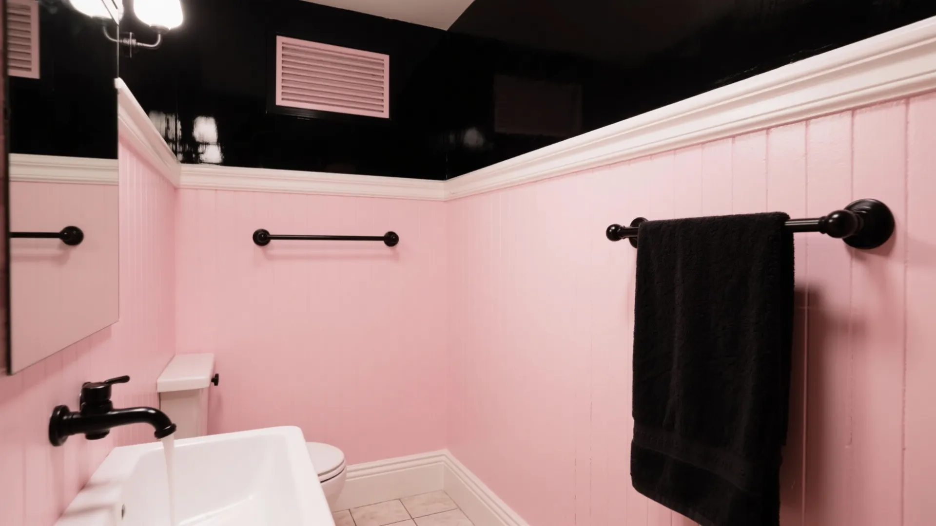 Compact bathroom with blush pink walls, satin black fixtures and white trim, showing vintage Hollywood glamour in a small space.