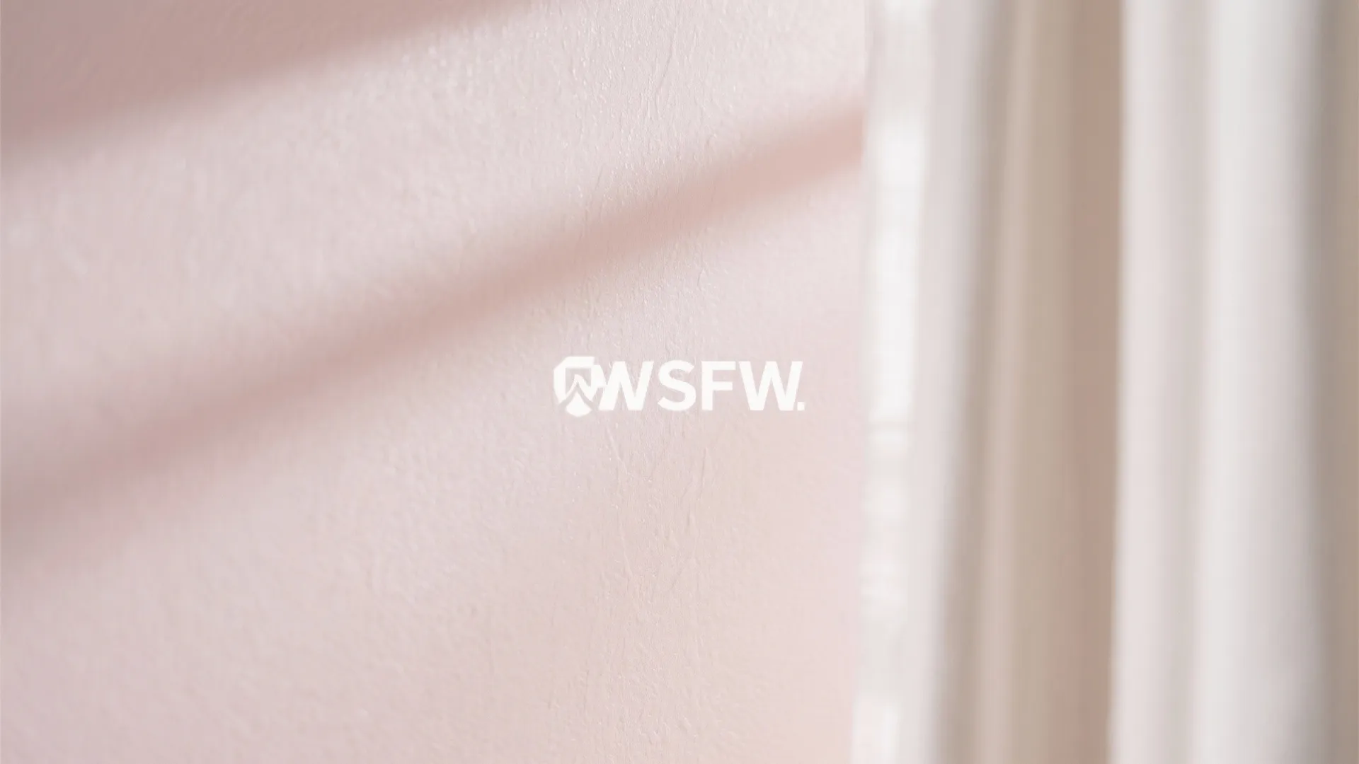Close up view of light pink textured wallpaper with soft shadows from white window curtains
