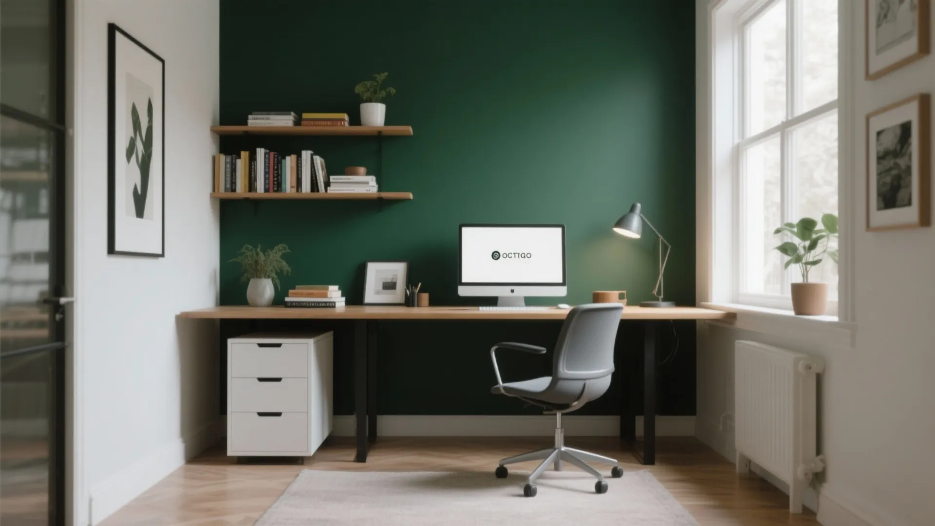 Minimalist home workspace with a dark green accent wall wooden desk and white cabinet drawers