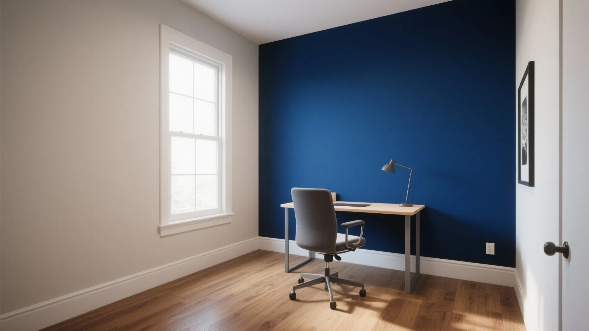 Minimalist study room with dark blue wall, wooden floor, simple desk, grey chair, and window