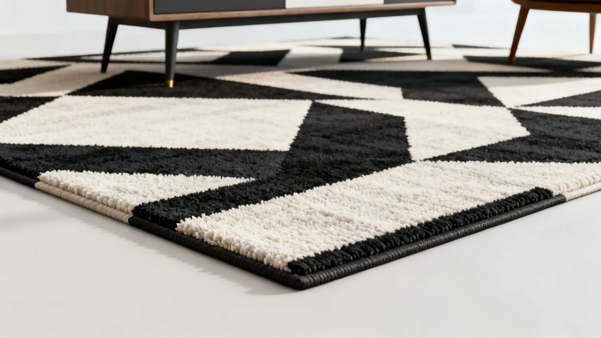 Black and white geometric pattern rug placed on the floor under a modern wooden cabinet