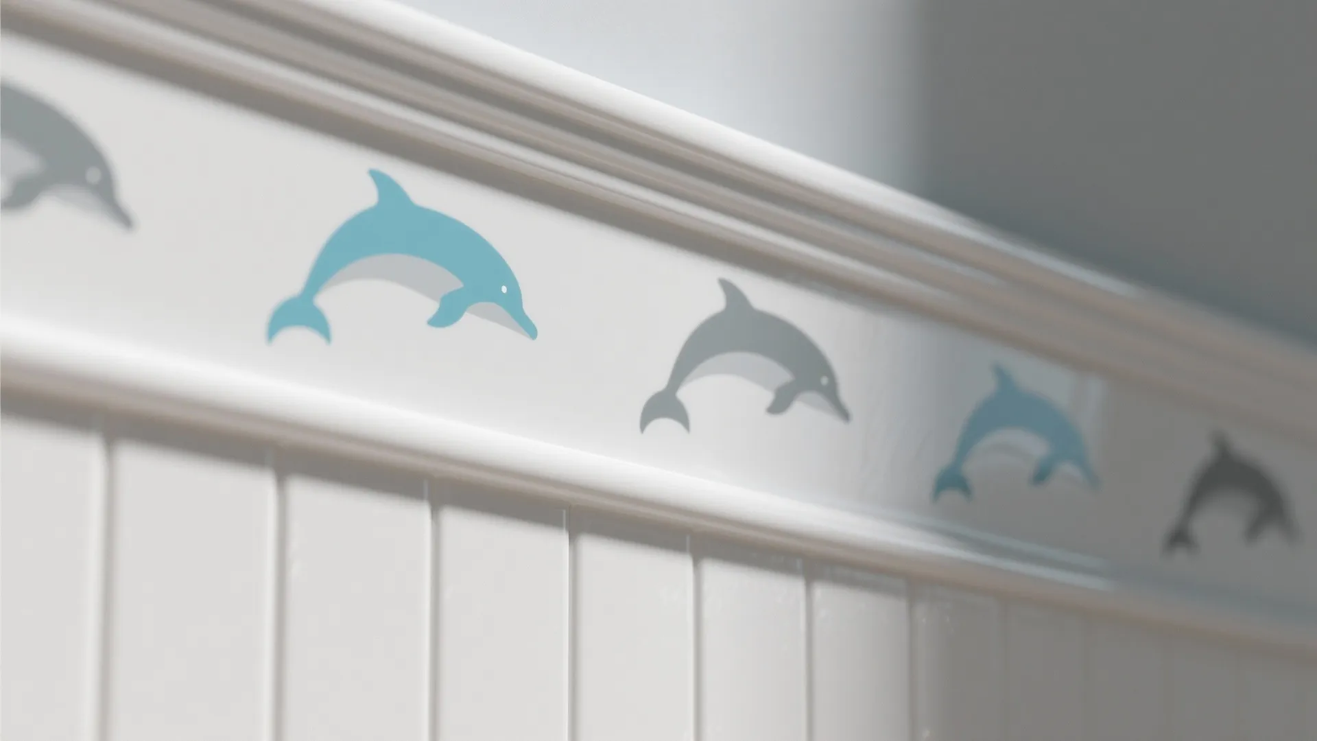 White wall panel with a decorative border featuring blue and grey jumping dolphin pattern designs