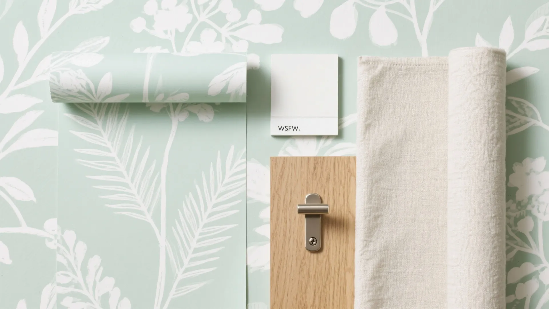 Interior design material flat lay featuring green floral wallpaper white paint wood sample beige fabric