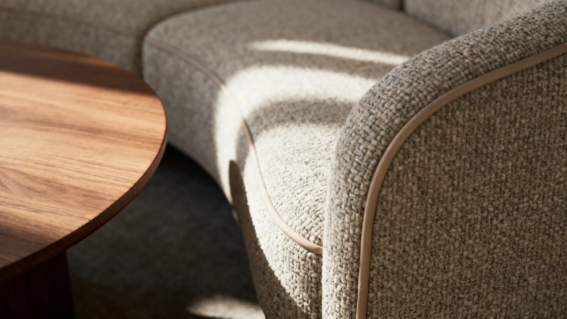 Macro of curved bouclé sofa seam next to a matte oak rounded coffee table.