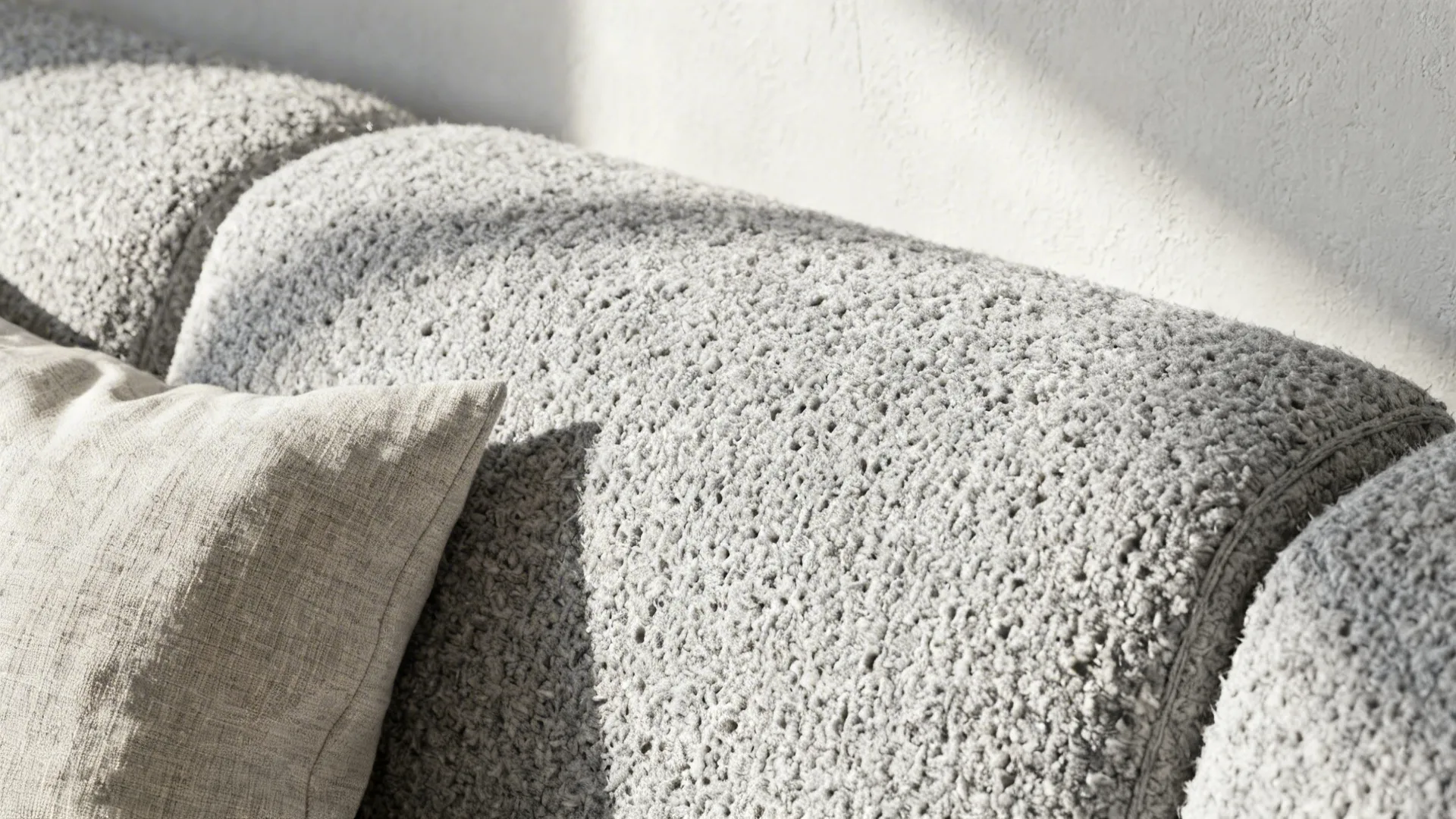 Macro textures of light gray bouclé, linen, and matte plaster in a neutral palette.