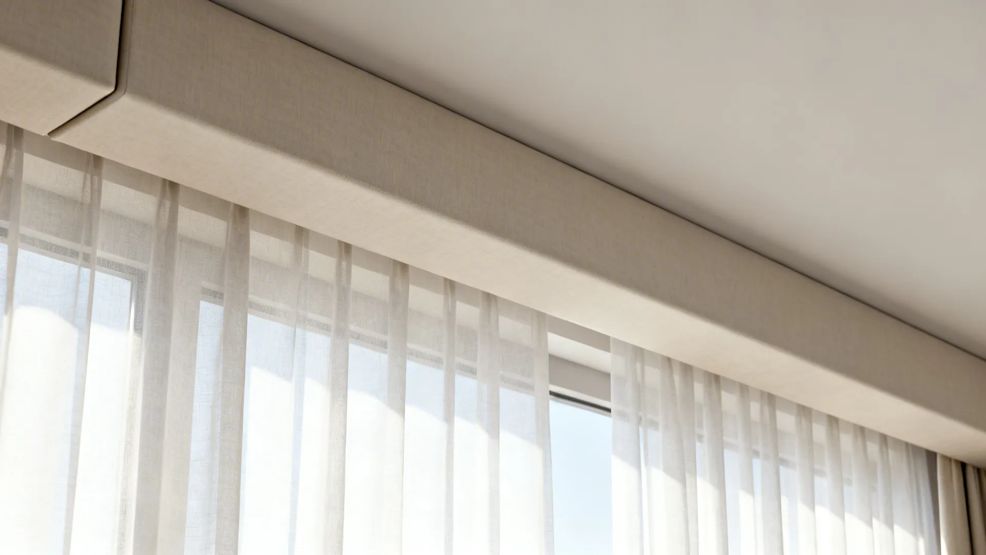 Close up of beige box curtain top covering thin white curtains in a sunny room