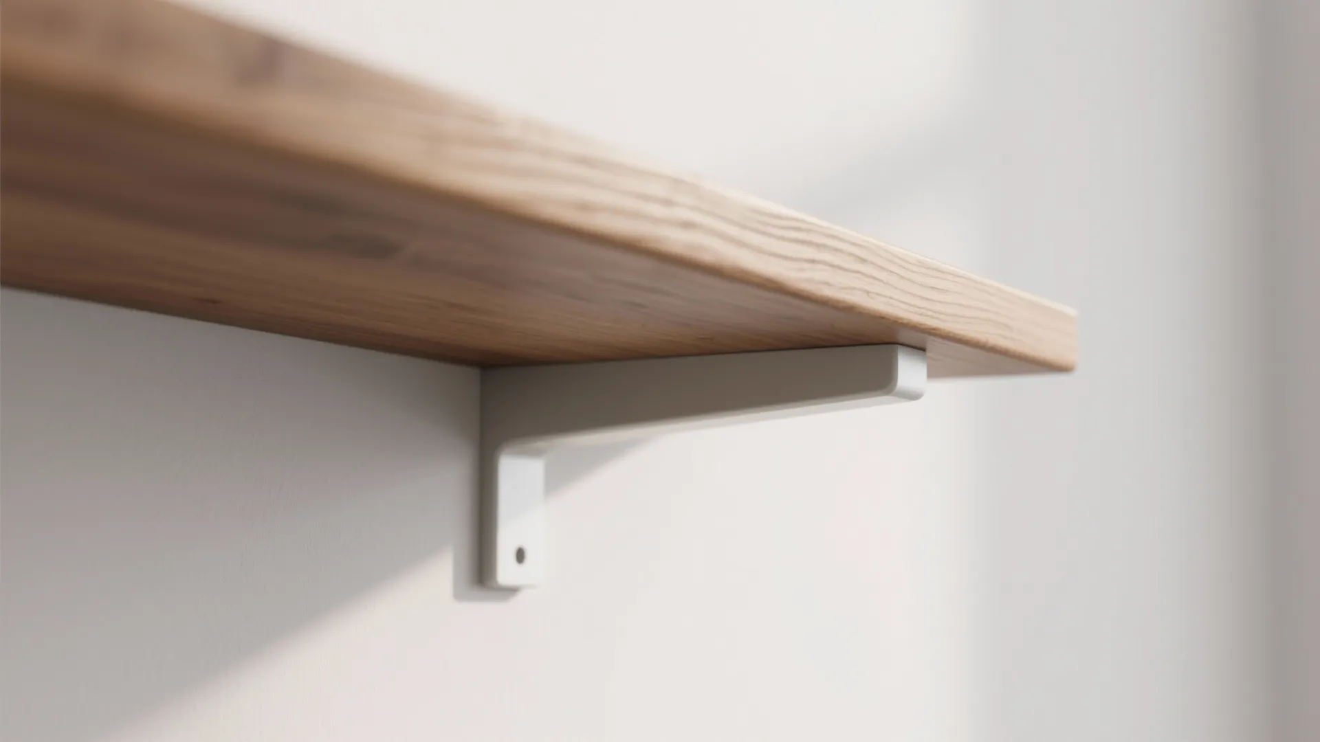 Close up view of a light wooden wall shelf supported by a white metal bracket