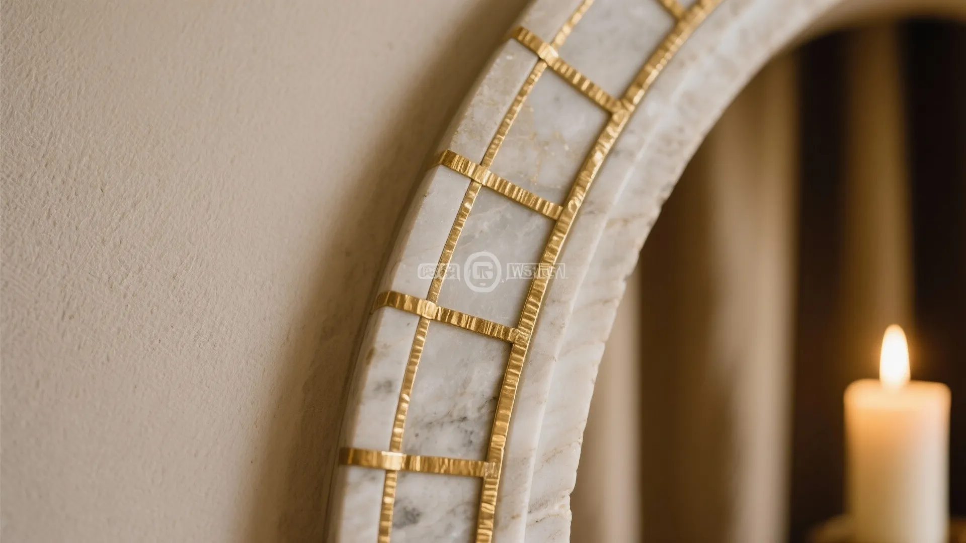 Arched marble wall detail with gold square pattern inlay next to a small white burning candle