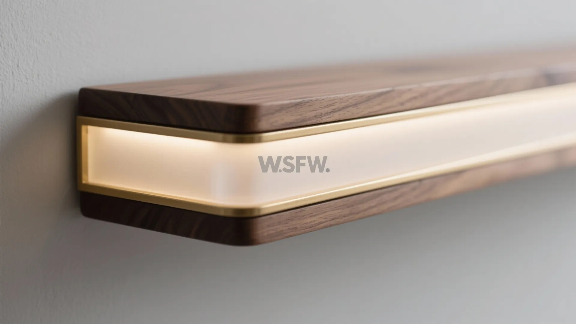 Close up of a modern wood wall shelf with gold metal trim and warm light