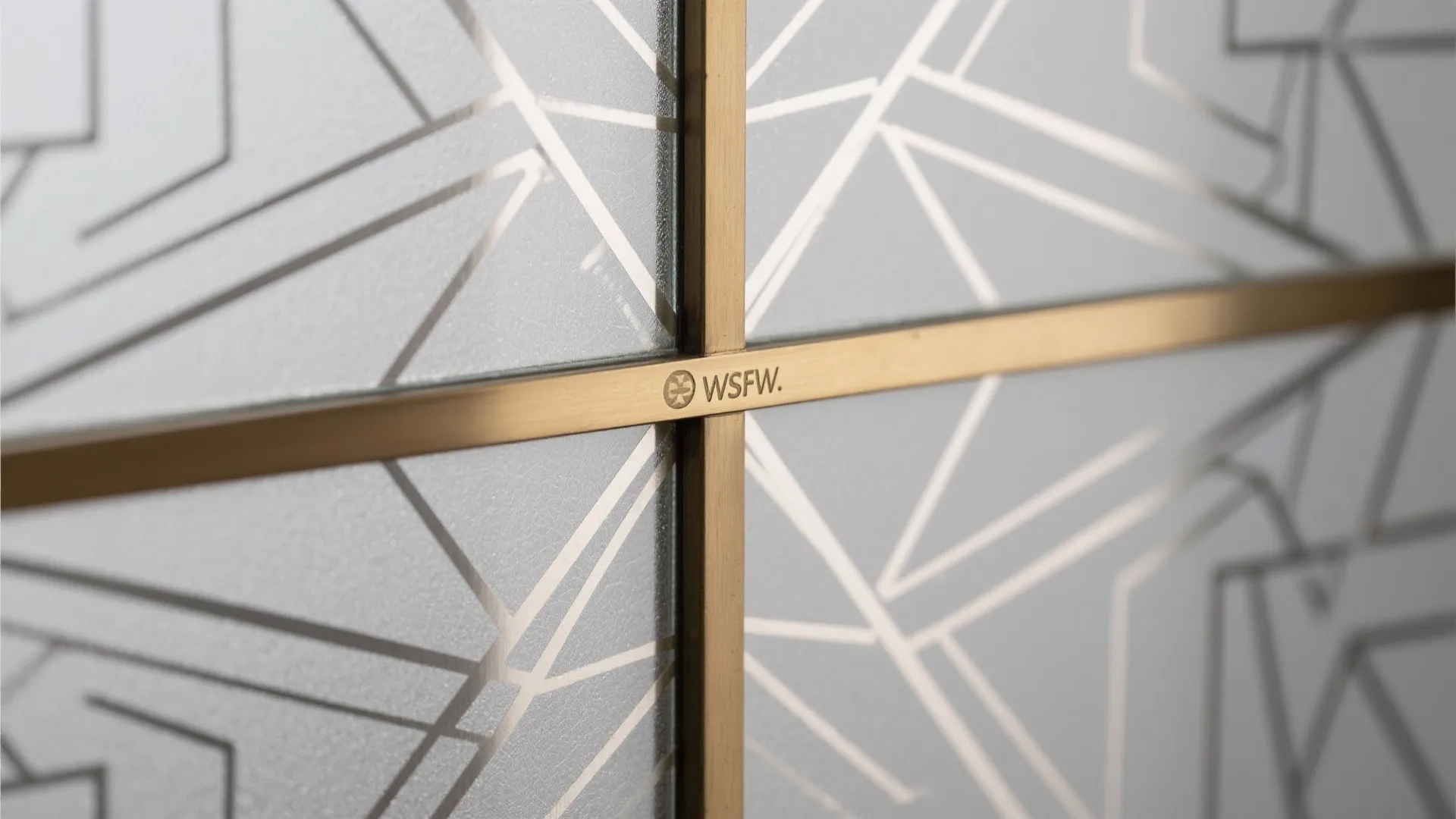 Macro of geometric frosted glass meeting a slim brushed brass trim with precise alignment.