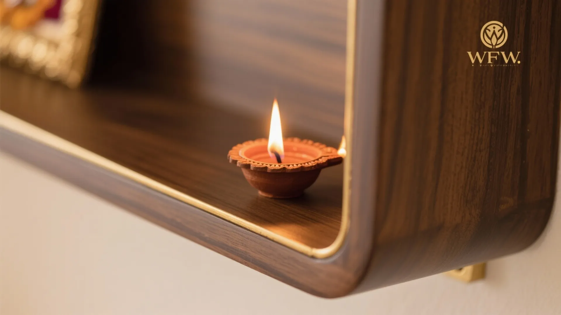 Close up of a small lit oil lamp placed on a dark wood wall shelf