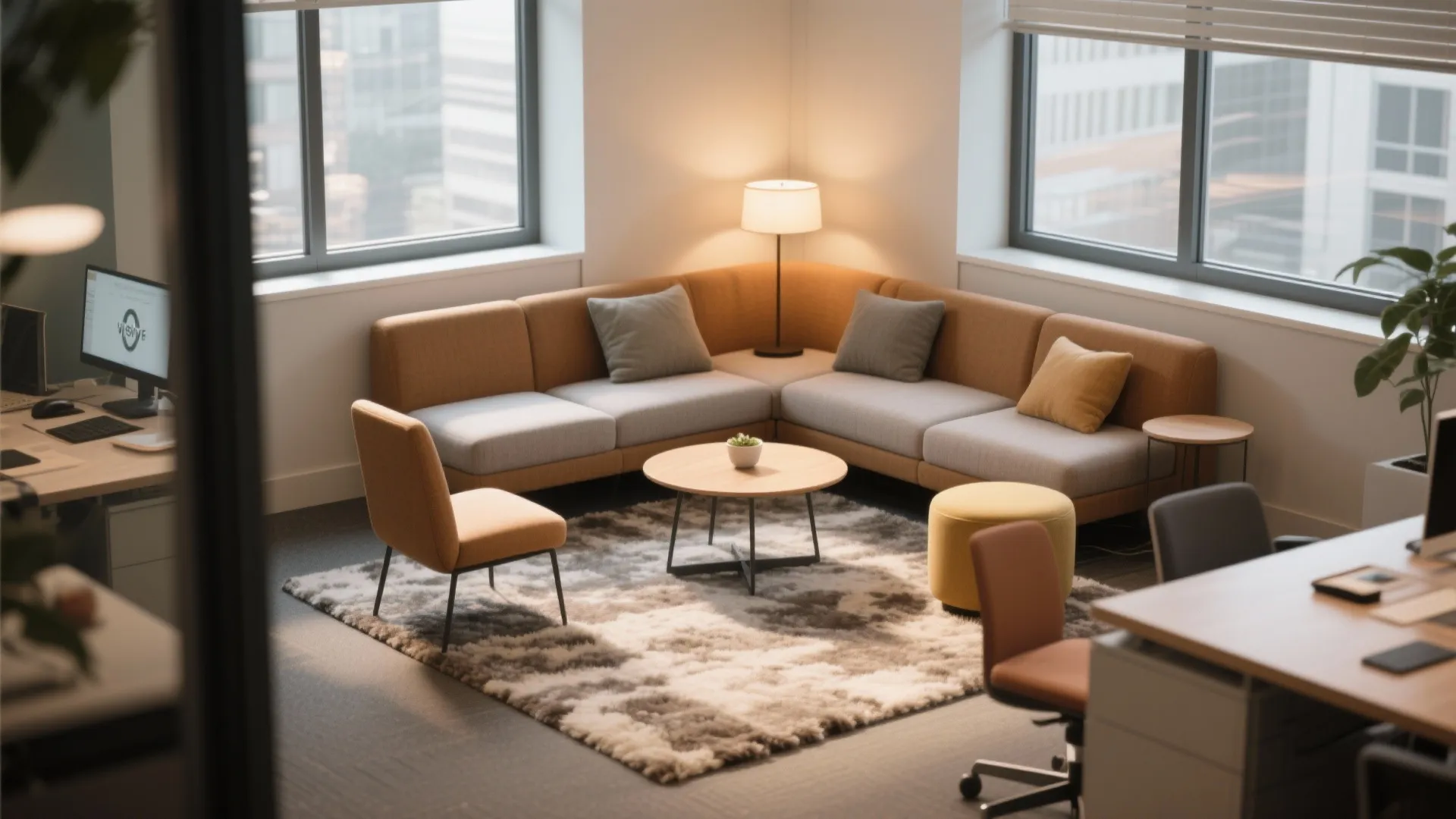 Office break room with corner sofa round coffee table rug floor lamp and large windows