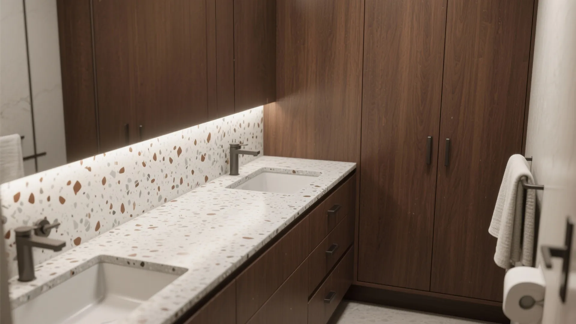 Walnut brown cabinetry paired with a light grey terrazzo countertop with brown chips.