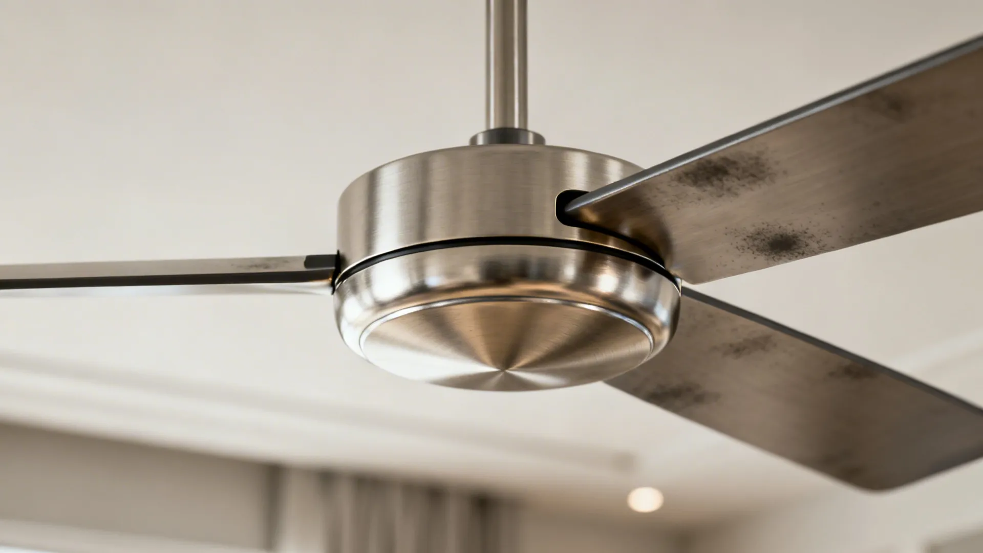 Macro of a brushed nickel ceiling fan hub showing subtle reflections and refined finish