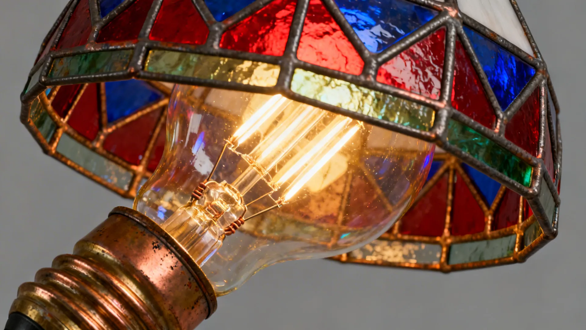 Close-up of a warm LED bulb glowing inside a Tiffany stained glass shade, showing texture and color.