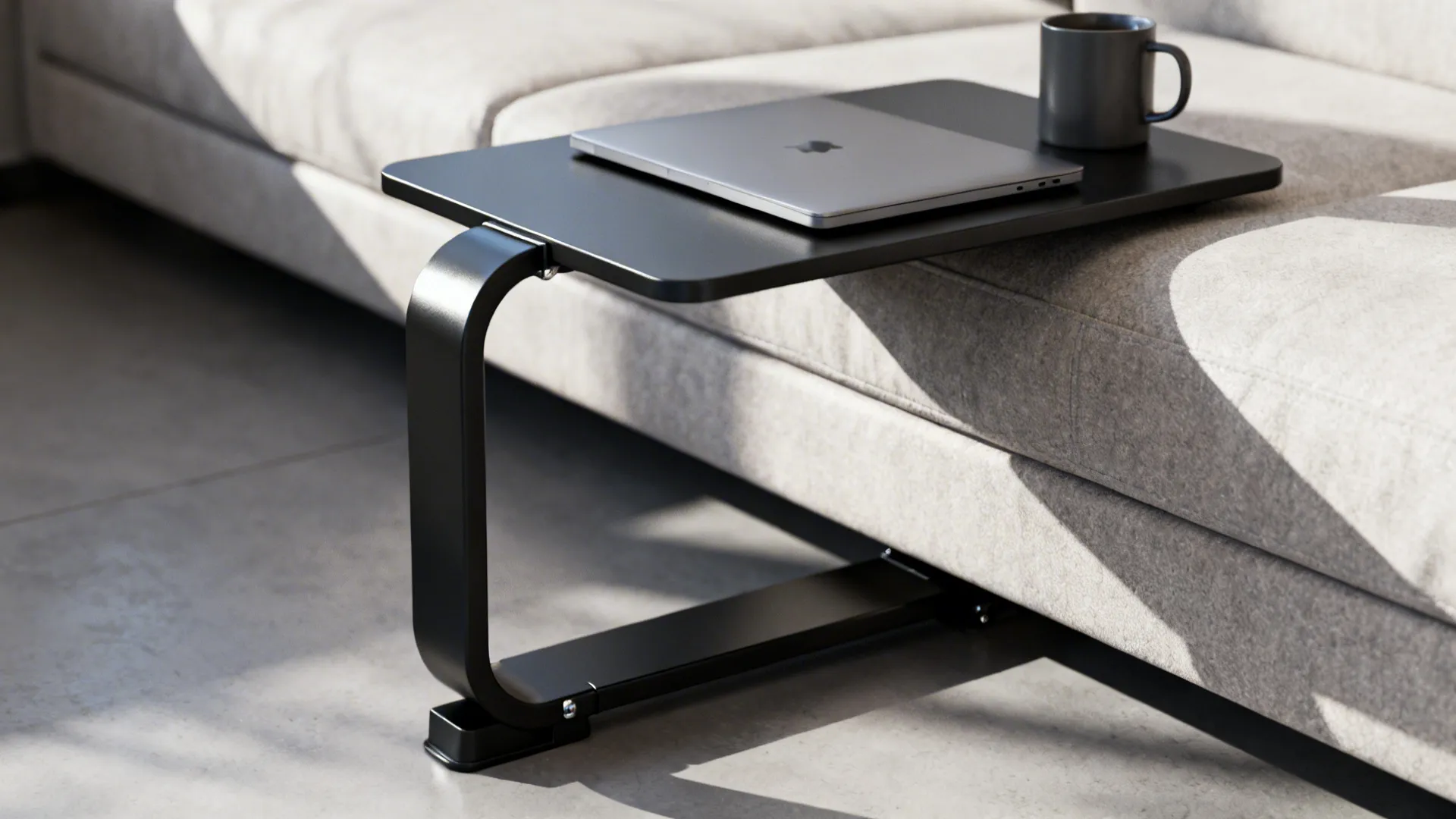 Close-up of a C-shaped matte black metal end table sliding under a sofa showing a weighted base.