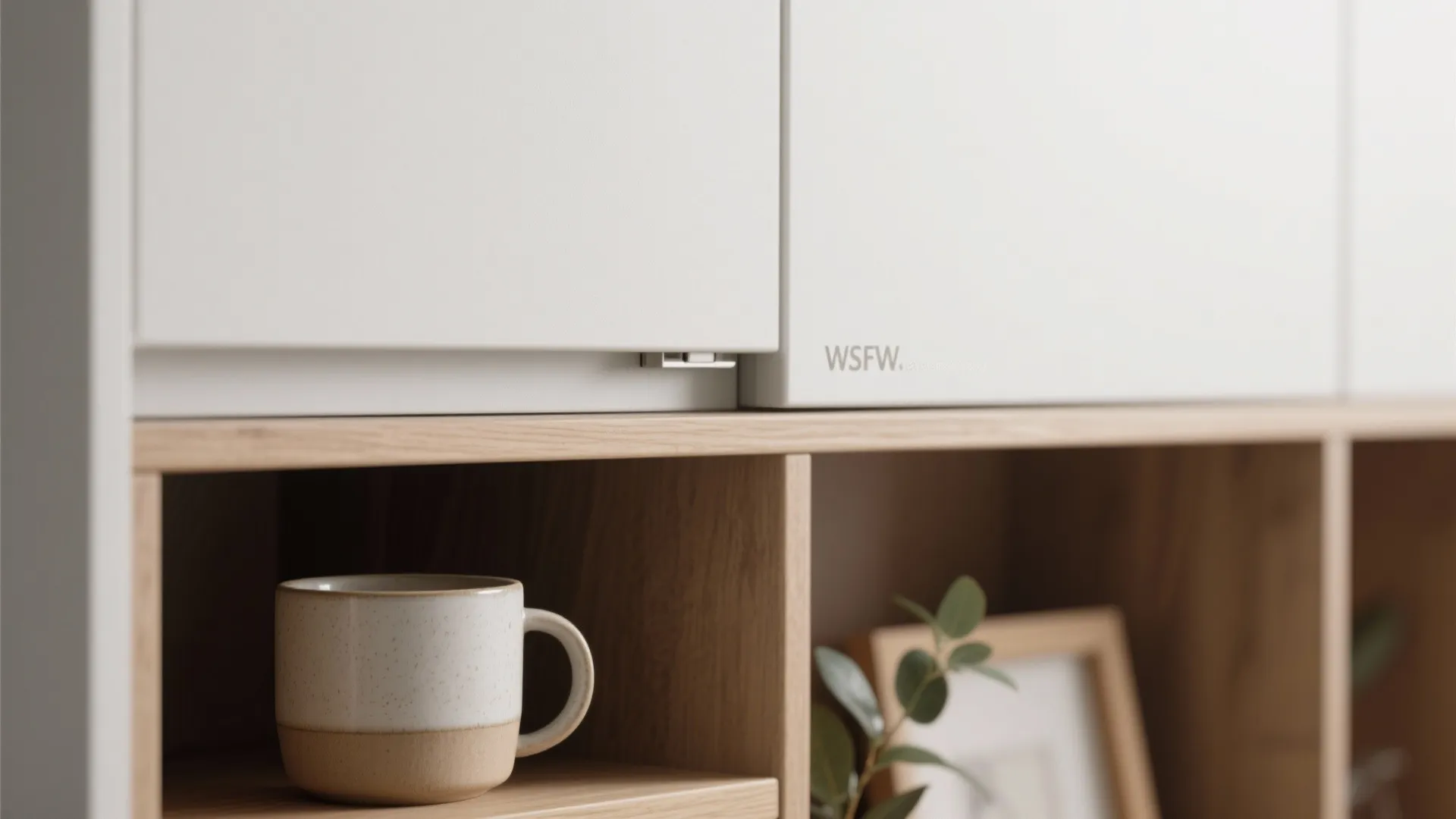 Close up of white cabinet doors and wooden open shelves with a coffee cup inside