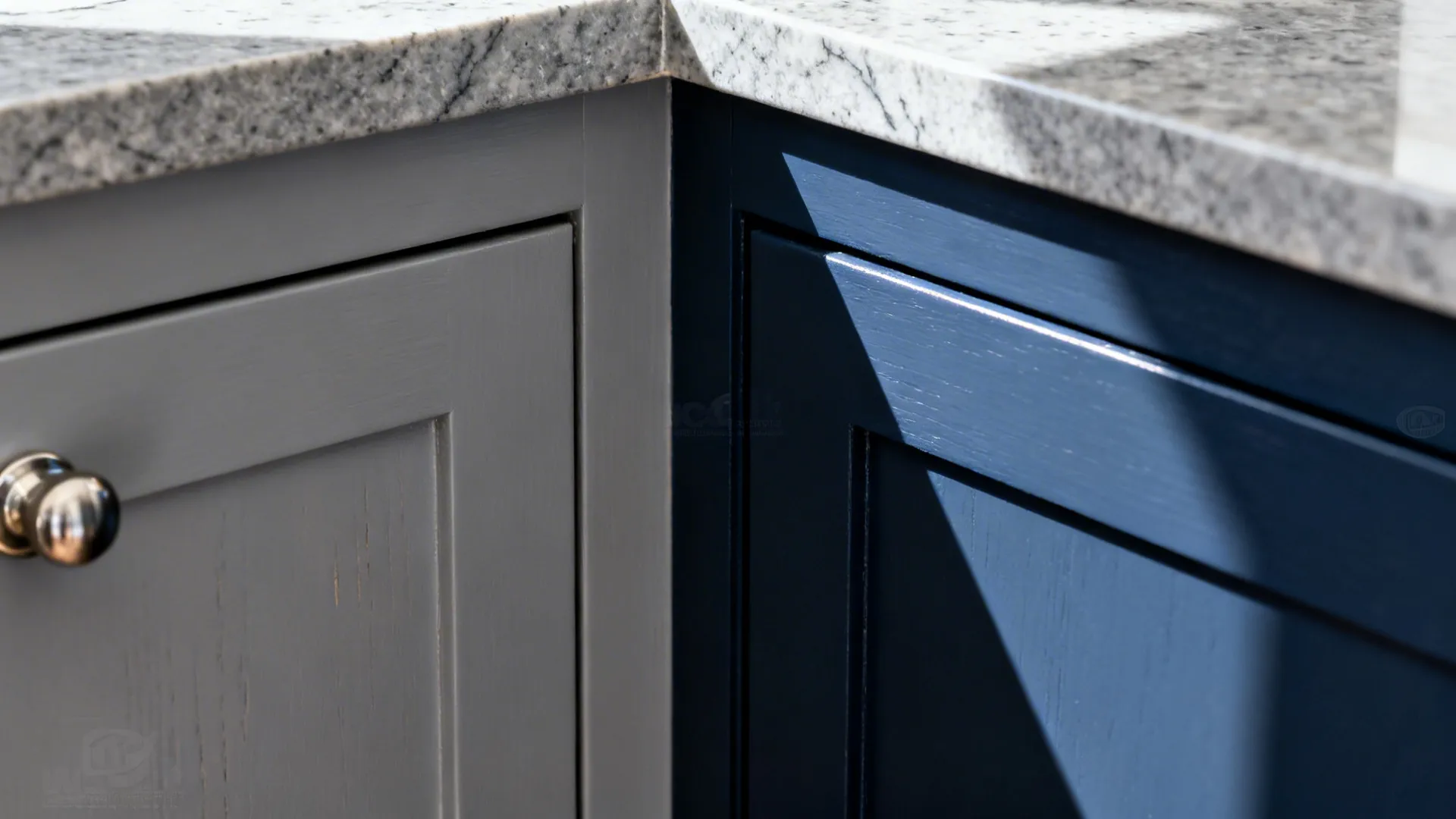 Macro of soft grey cabinet, deep navy island paint line, nickel pull, and honed quartz edge.
