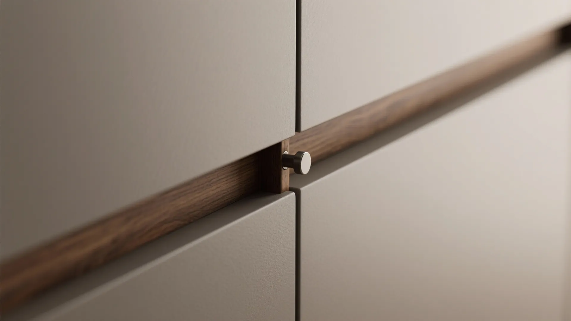 Close up of grey kitchen cabinet doors with a small round metal handle and wood trim