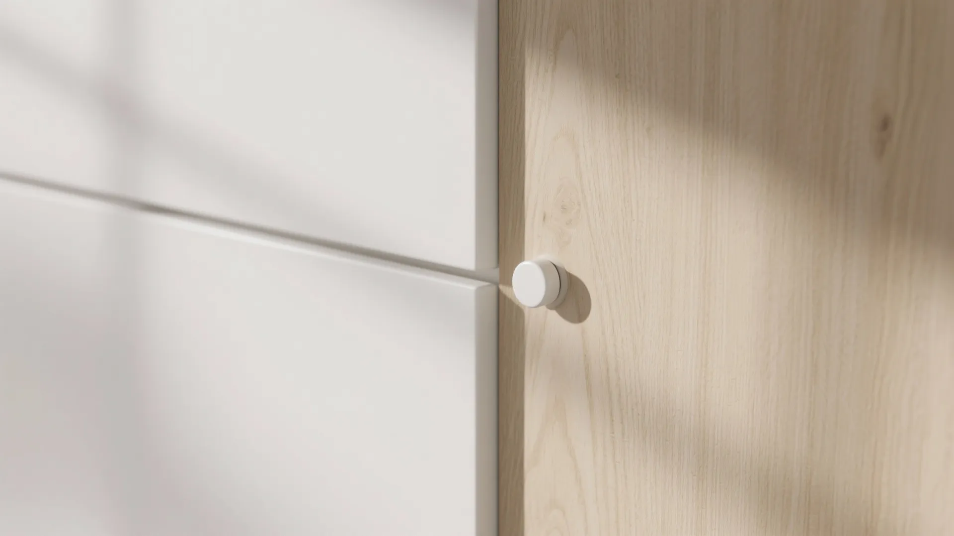 Close up of a wooden cabinet with white doors and a small round door handle