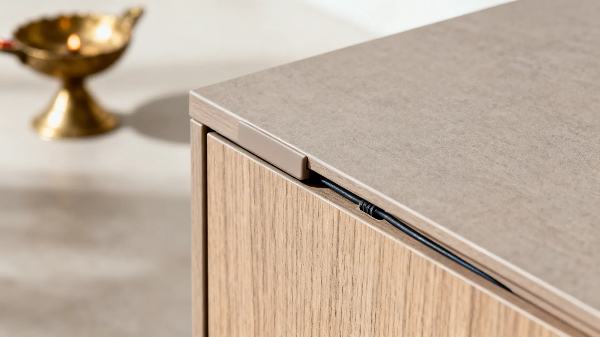 Macro view of matte laminate cabinet edge with push-to-open detail and concealed wiring port.