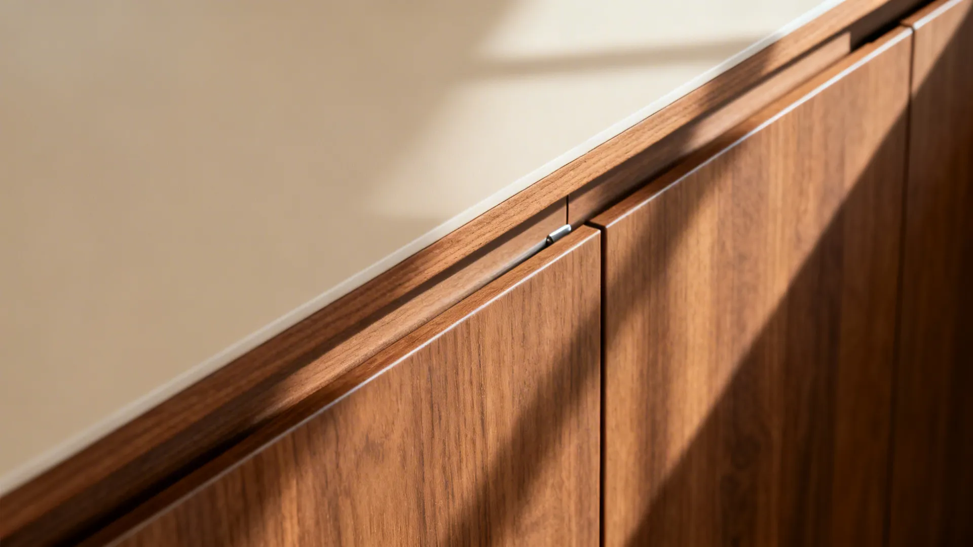 Macro of matte handleless cabinet channel showing teak and beige finishes with clean edge banding.