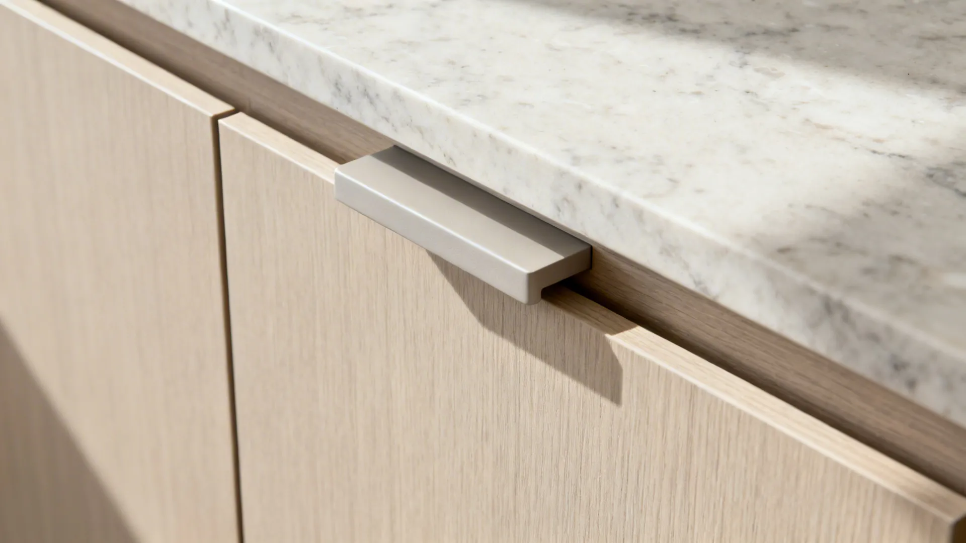 Macro detail of integrated cabinet pull on a matte slab door with soft daylight.