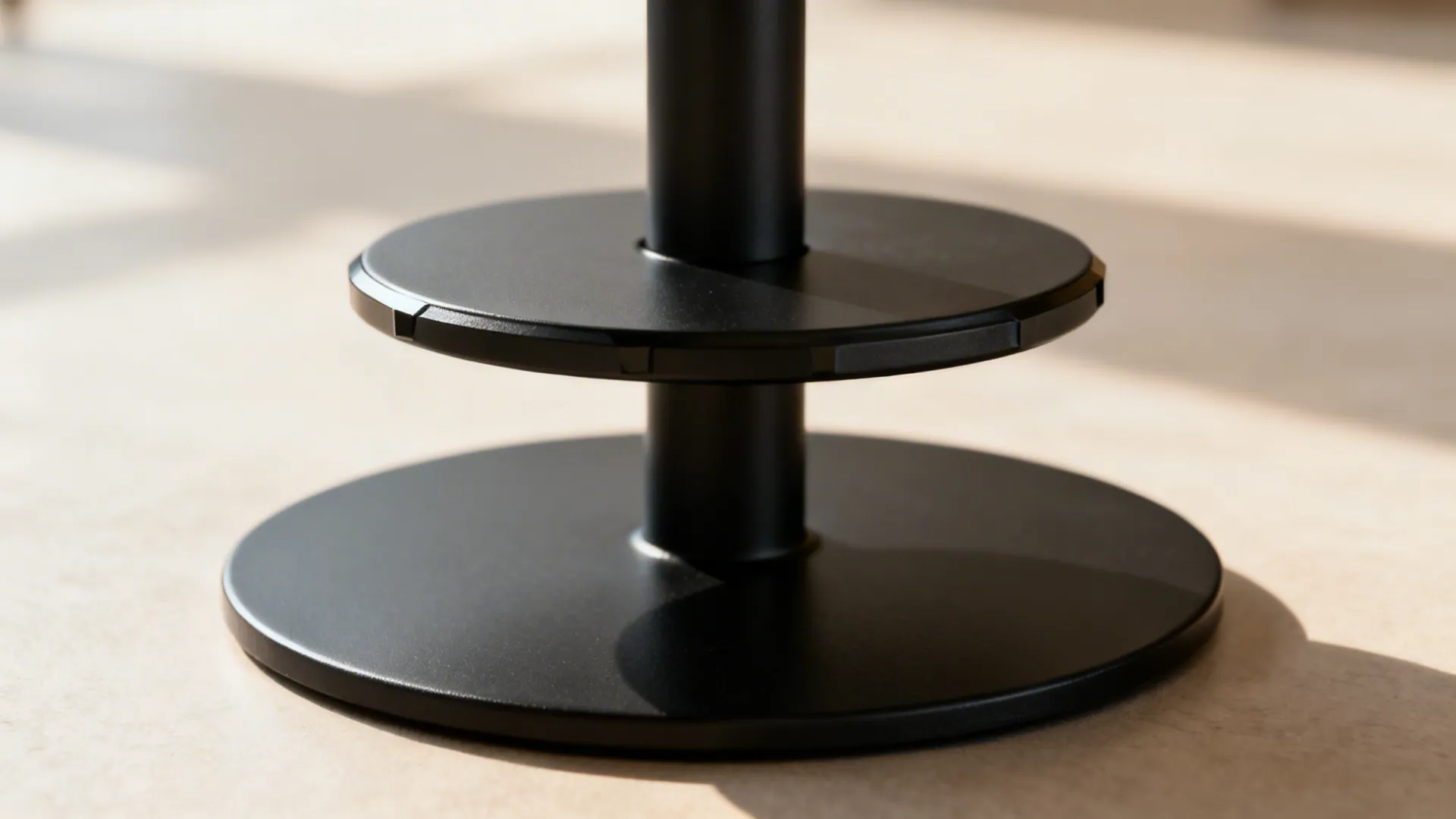 Macro of a weighted black pedestal base with a beveled tabletop edge.