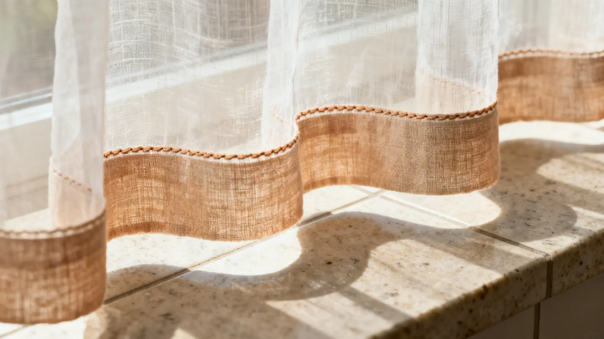 Macro of a sheer café curtain hem with a tailored linen-cotton bottom band.