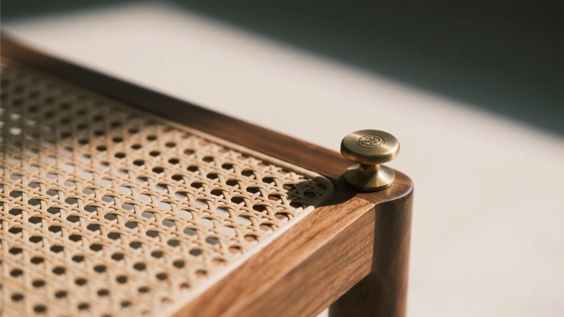 Close up view of wooden furniture with woven pattern and a small round brass knob