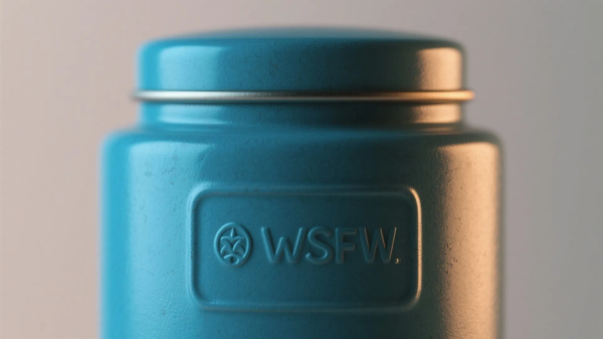 Close up view of a blue ceramic kitchen jar with embossed letters and textured finish