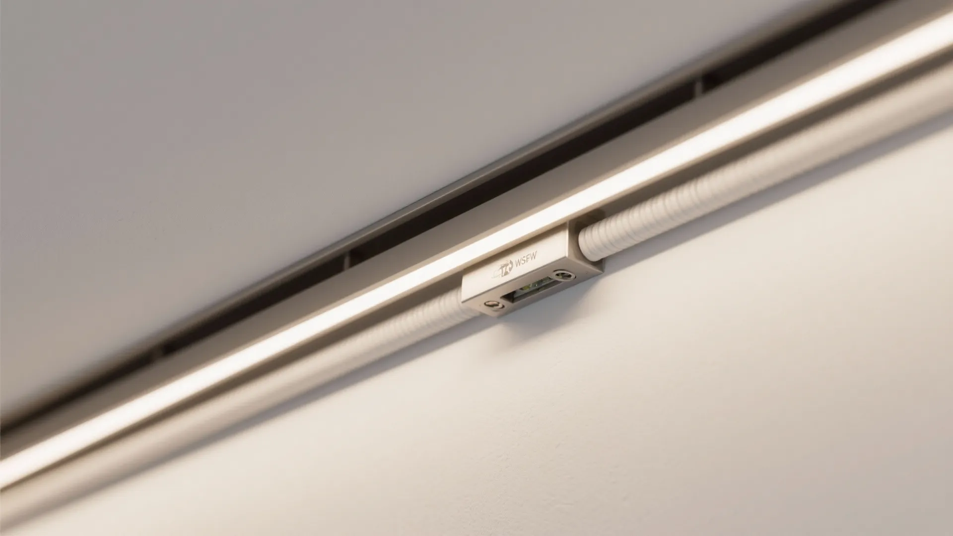 Close up of linear light fixture mounted inside a recessed white ceiling track for home lighting