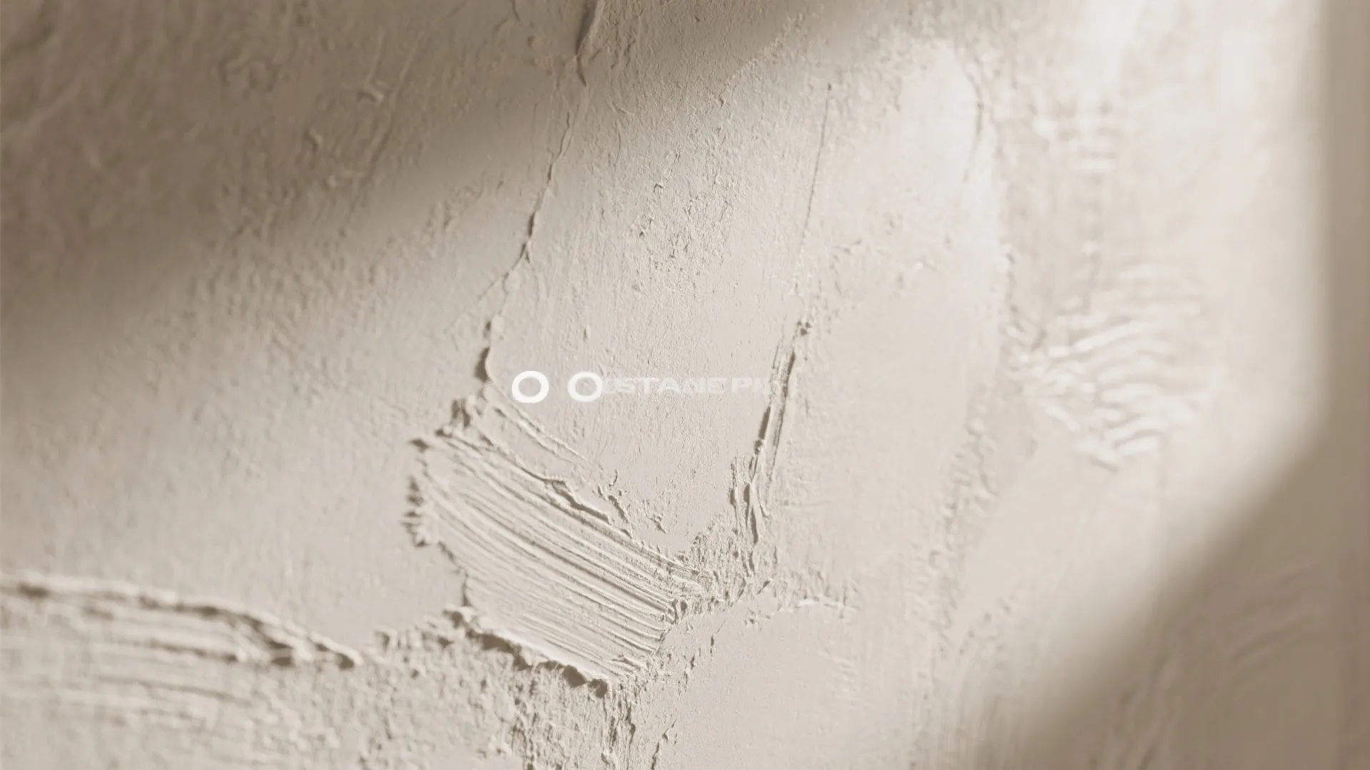 Detailed view of light beige wall with rough plaster finish showing natural brush stroke patterns