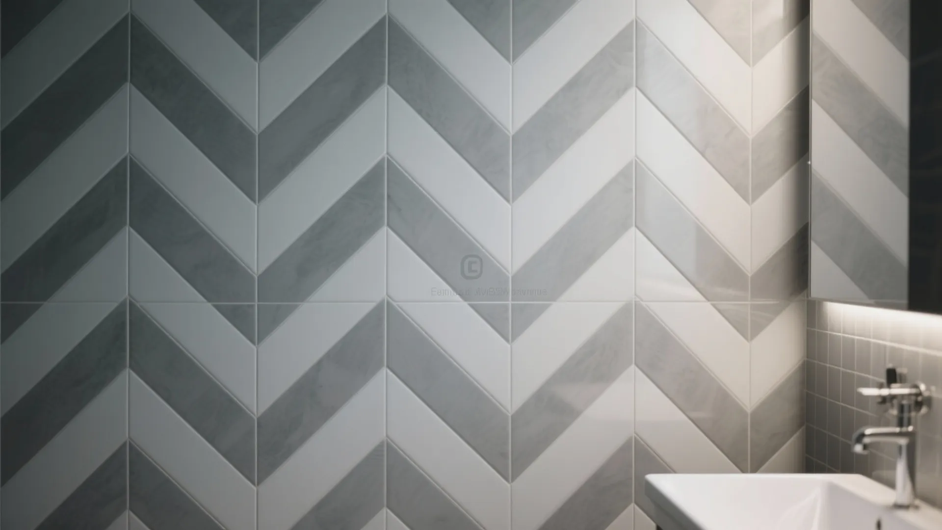 Bathroom wall design with grey and white zigzag tiles, white sink, and chrome water tap