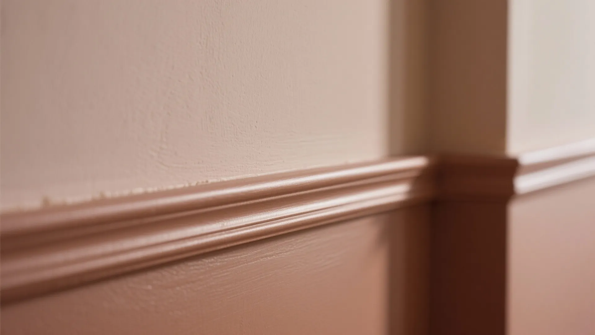 Close up of pink painted wall with a horizontal decorative wood wall panel and soft light