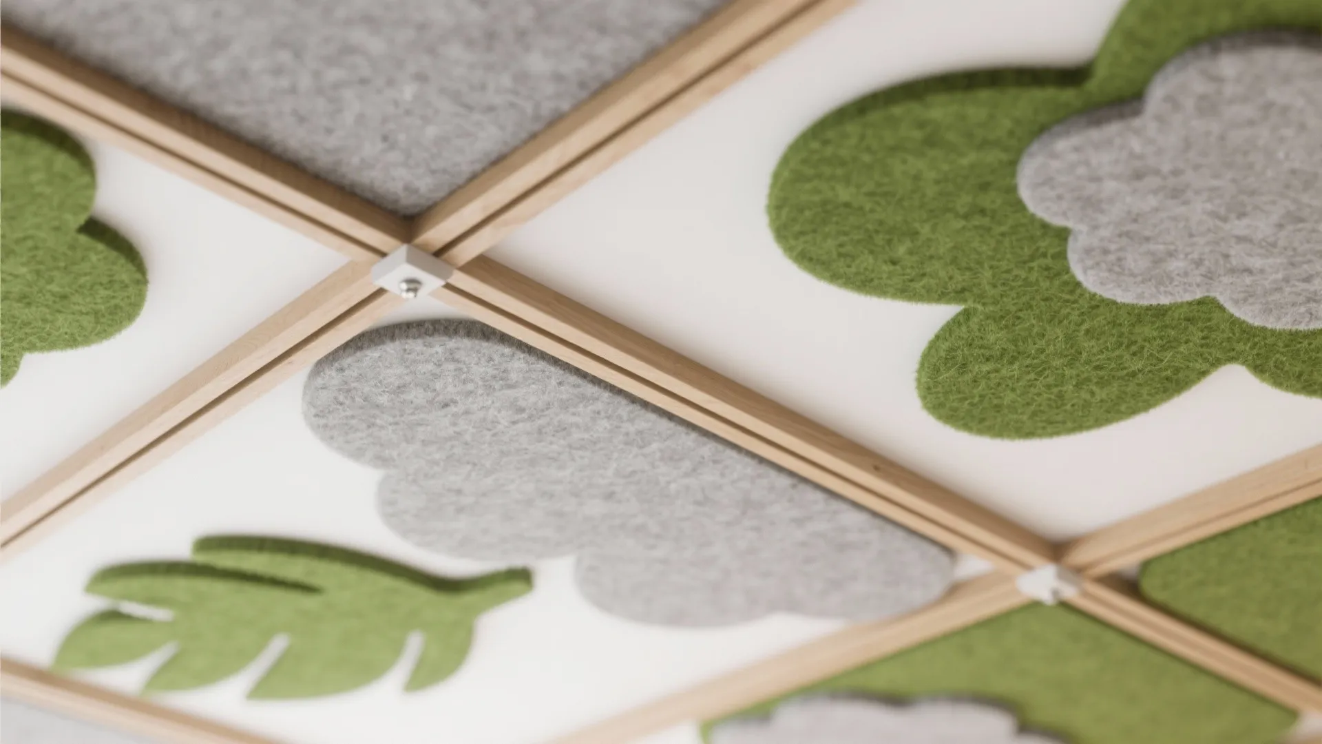Close up of ceiling with green leaf and grey cloud felt decorations on wood frames