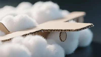 Cardboard Airplane Amidst Cotton Clouds – A Playful Design Inspiration