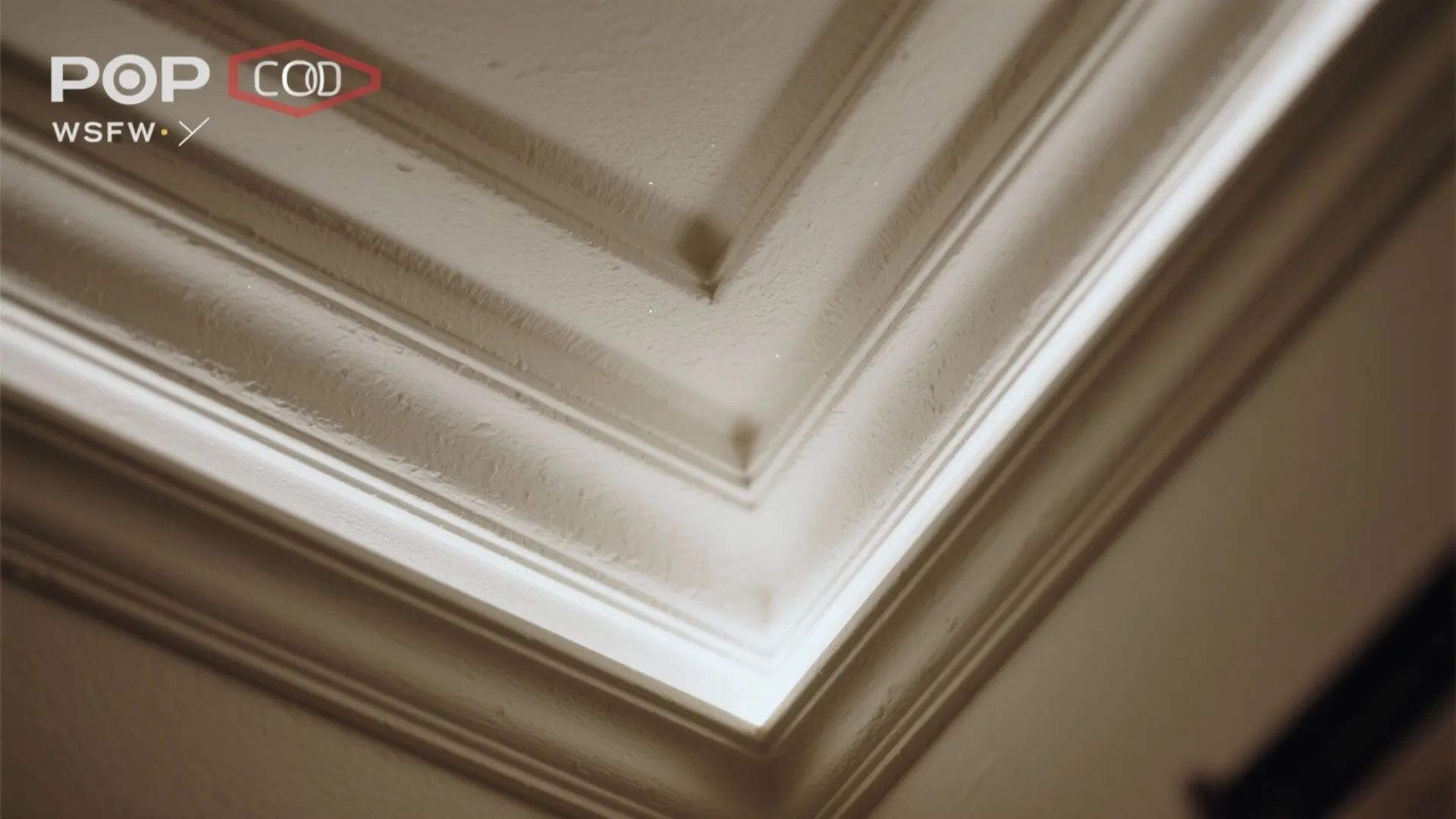 Close up view of white ceiling corner with hidden light fixture showing modern interior design