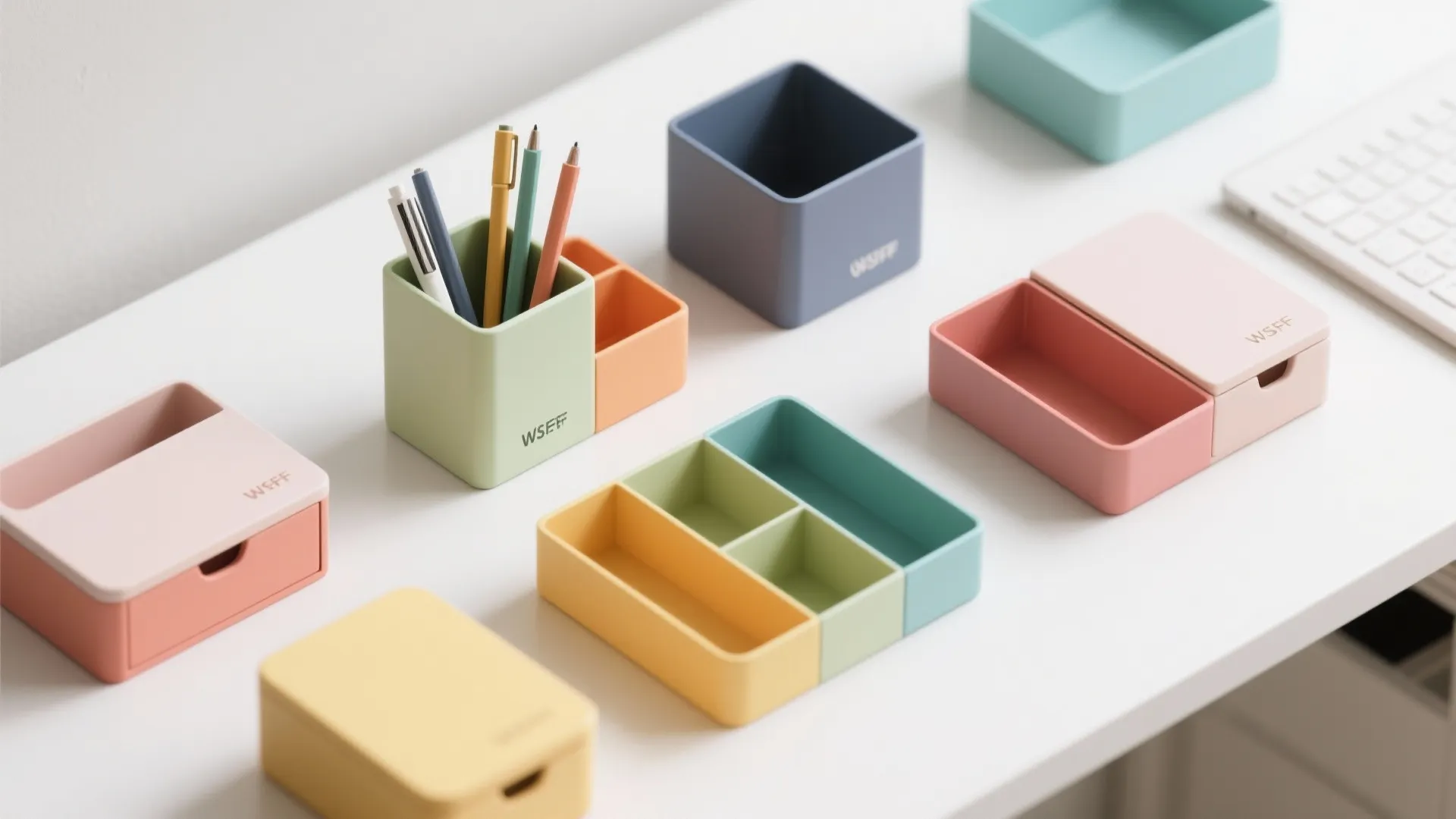 Colorful pastel plastic desk organizers and pen holders arranged on a white home office table