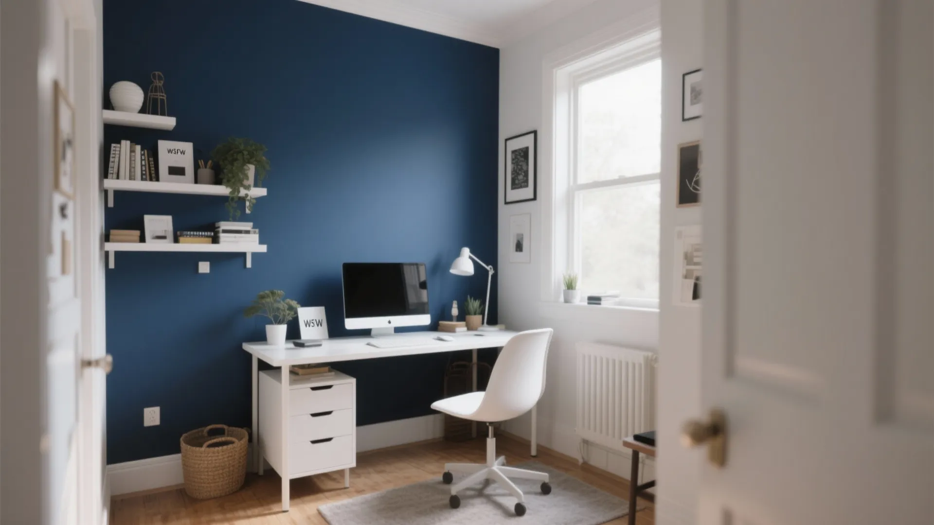 Small home office with a deep navy accent wall behind a white desk