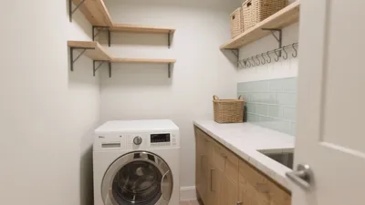 Compact Laundry Room with Wood Shelving and Tile Backsplash