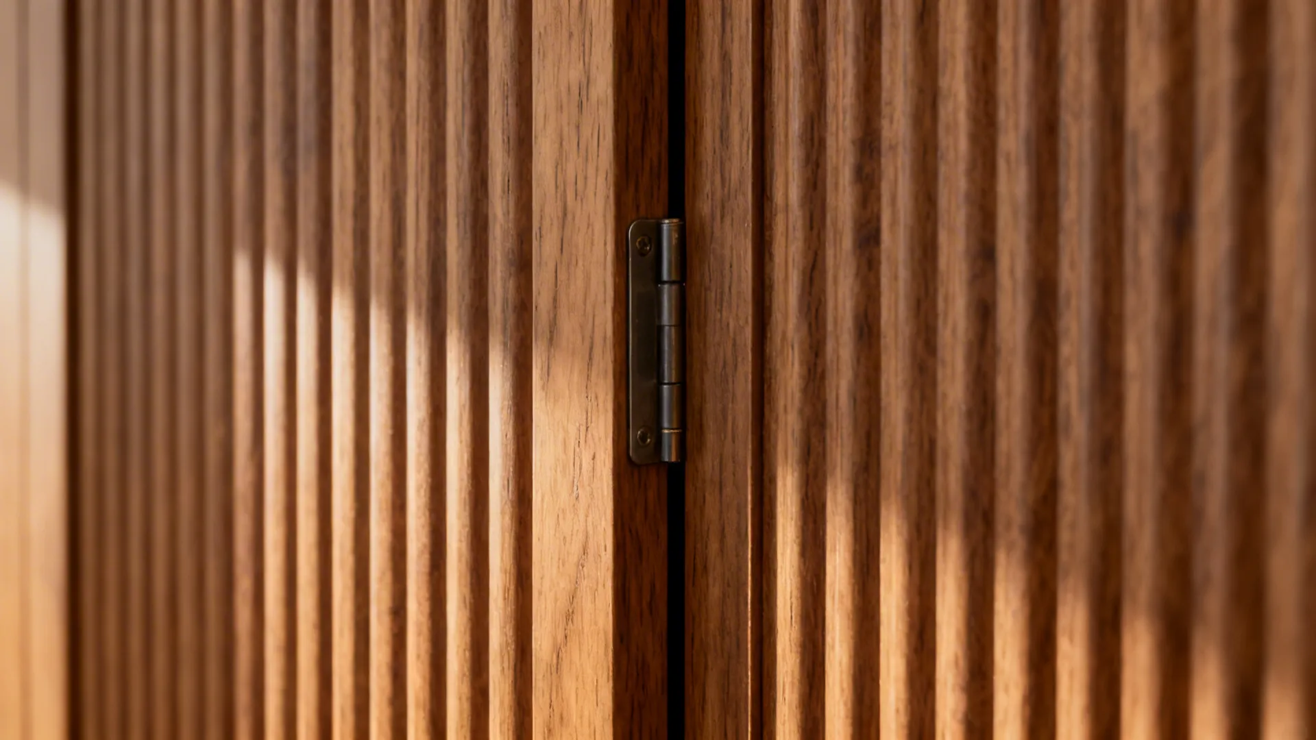 Macro of fluted wood panels showing a hidden door seam and precise hardware alignment.