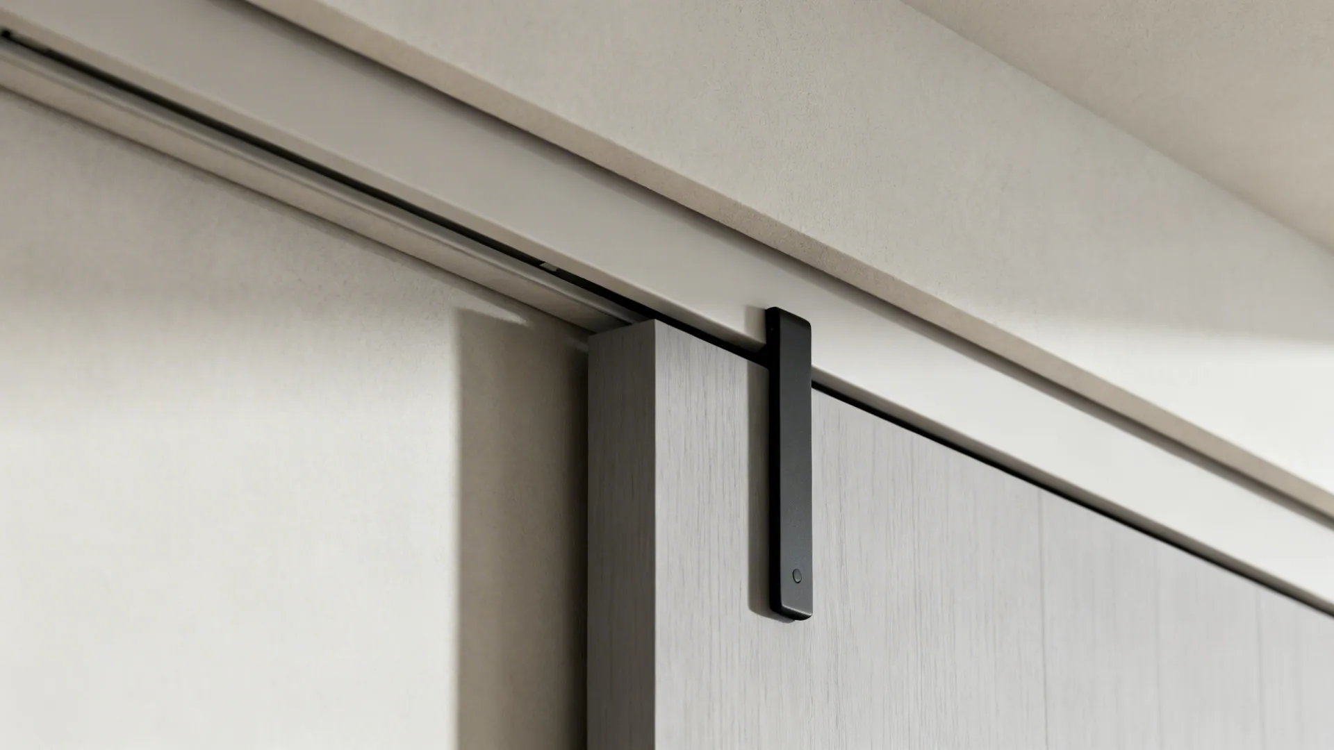 Macro view of a concealed barn door track with matte panel and slim pull.