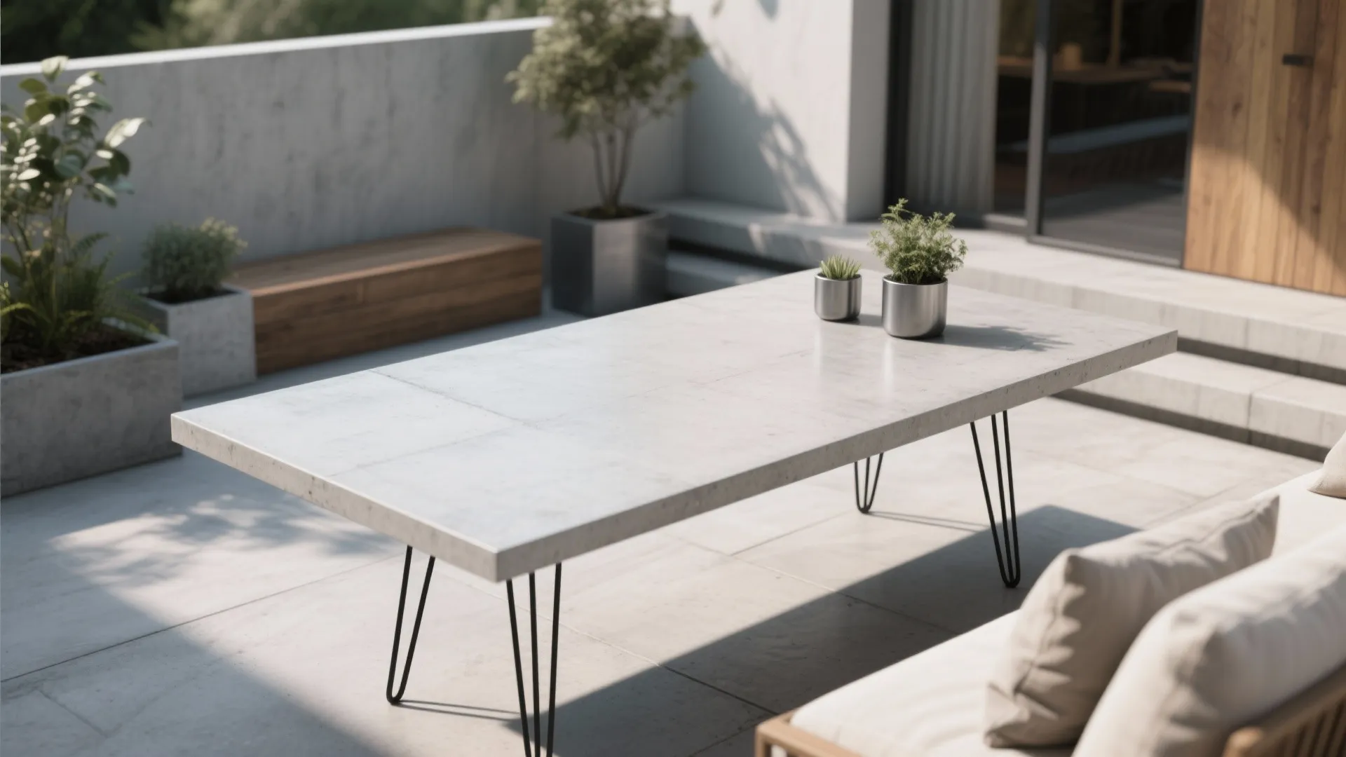 Modern concrete slab table with black hairpin legs on a sleek outdoor patio.