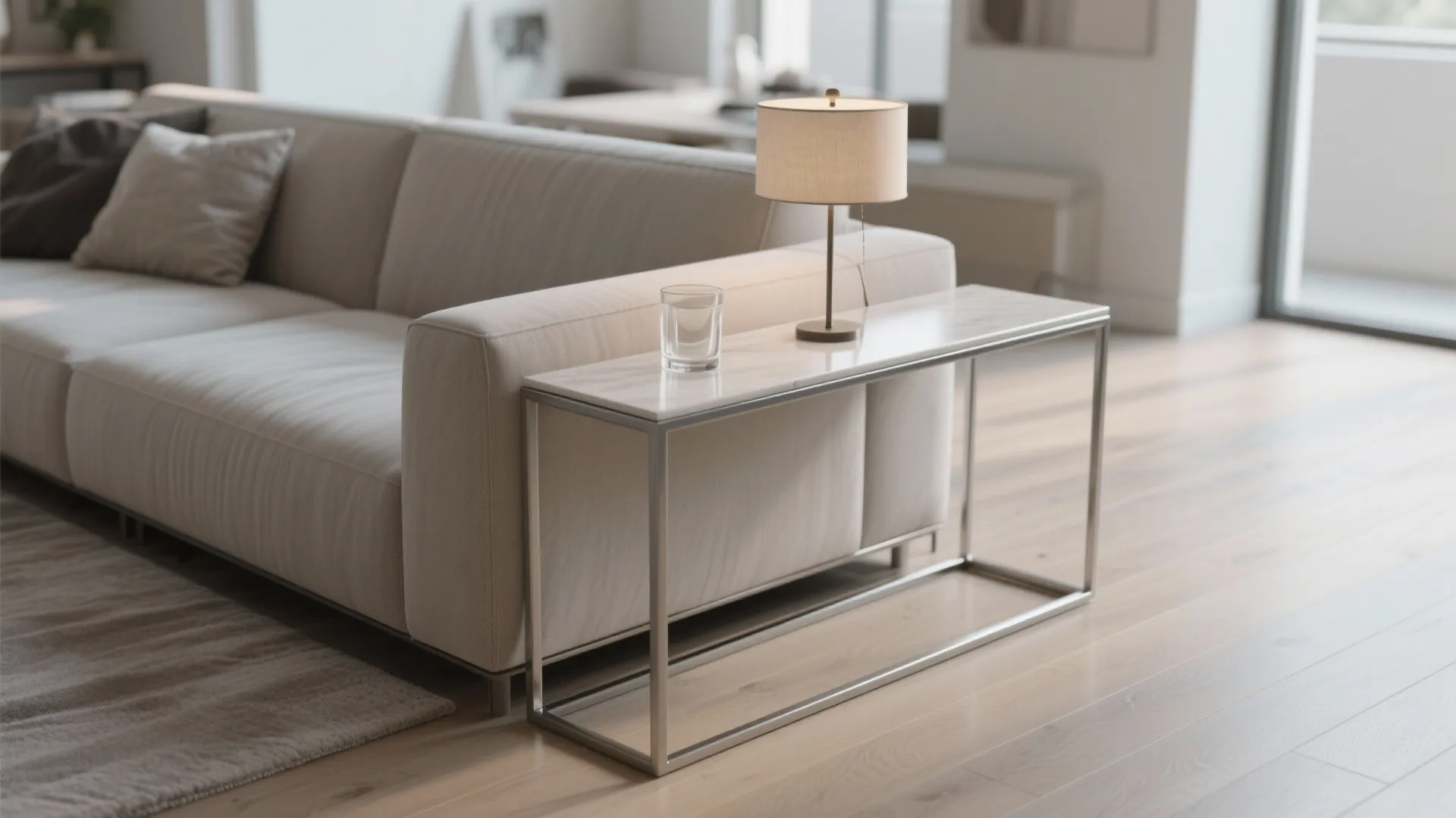 Modern living room with beige sofa and marble console table holding a lamp and water glass